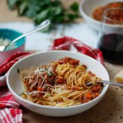 Low FODMAP Bolognese served in a bowl on spaghetti.