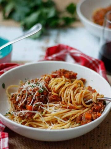 Low FODMAP Bolognese served in a bowl on spaghetti.