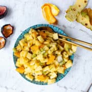 Australian Winter fruit salad piled high in a blue patterned bowl.