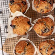 Sugar-crusted blueberry muffins cooling on a rack.