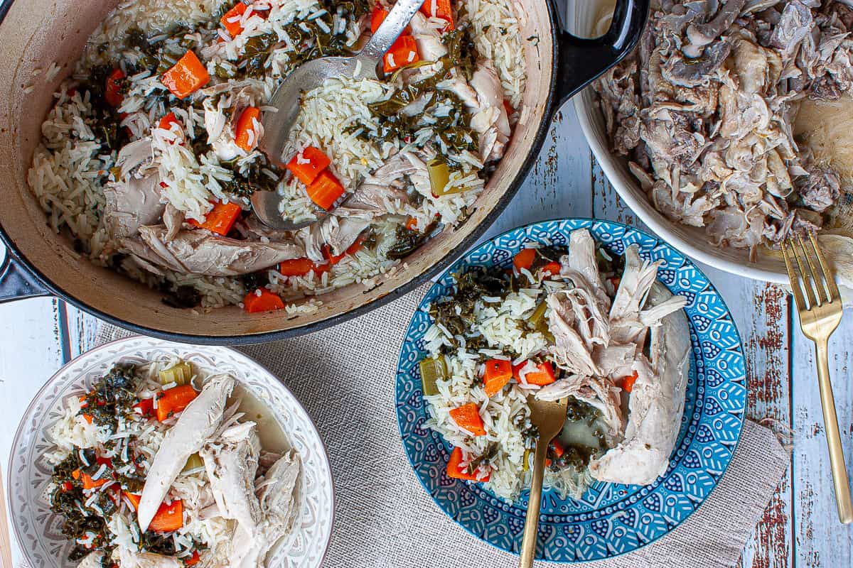 Bowls of chicken, rice and vegetables. The bones of the chicken are in a bowl.