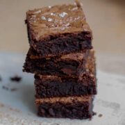 Stack of four brownies sprinkled with salt.