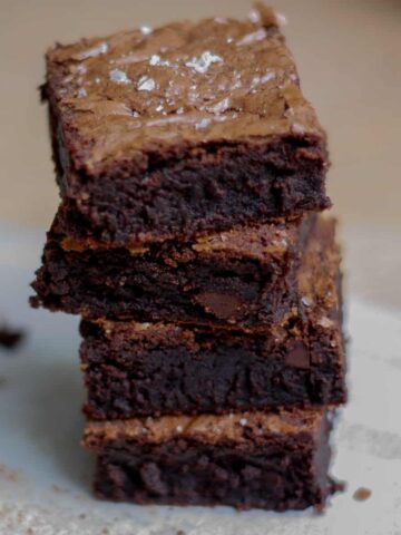 Stack of four brownies sprinkled with salt.