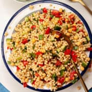 Colourful giant couscous salad in a large bowl.