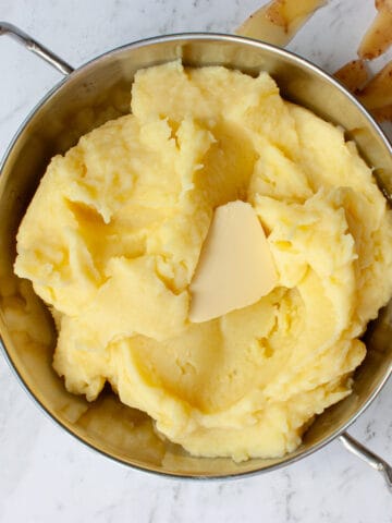 Creamy buttery mash in a silver serving bowl.