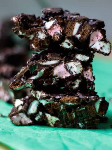 A stack of rock road pieces - chocolate studded with pink and white marshmallows and flecks of green.