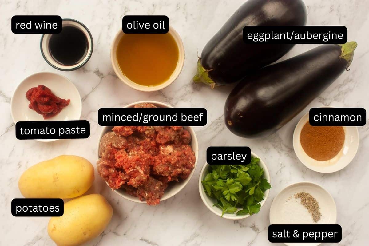 Annotated flat lay of ingredients needed to make moussaka (minus the topping).