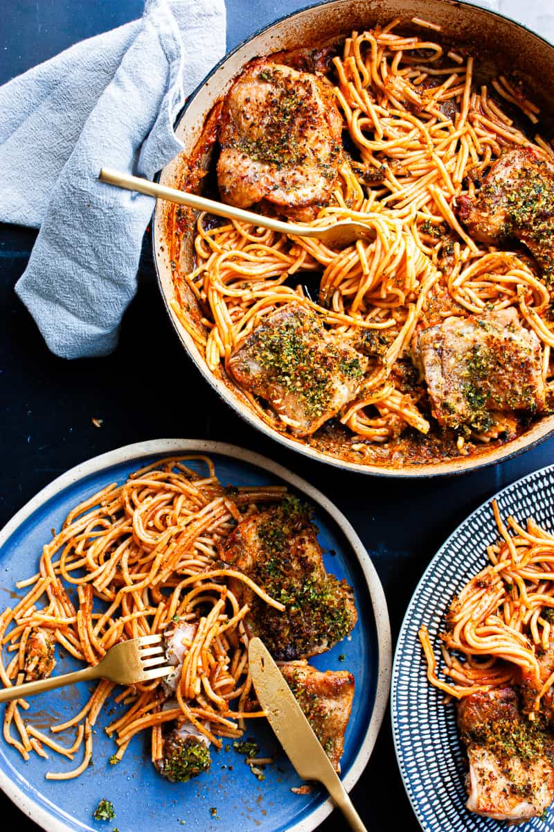 Tangle of spaghetti strands with chicken pieces served family-style.