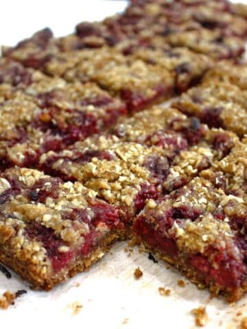 Slice cut into small rectangles on a wooden chopping boards. Some loose crumbs around the edge.