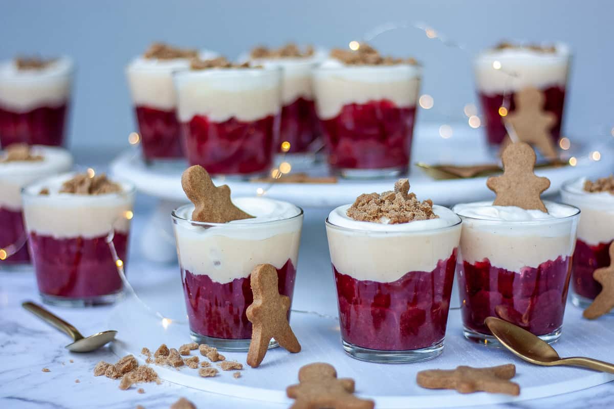 Twelve rhubarb, custard and gingerbread trifles. Little gingerbread men in and around the glasses.