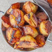 A pile of very crispy-looking roast potatoes in a silver bowl.