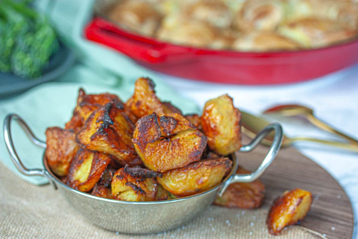 A pile of very crispy-looking roast potatoes in a silver bowl.