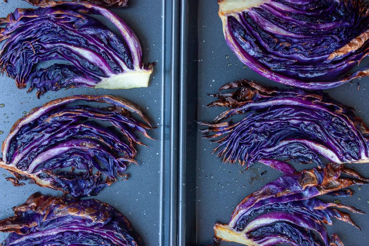 Roasted cabbage slices set over two baking trays.