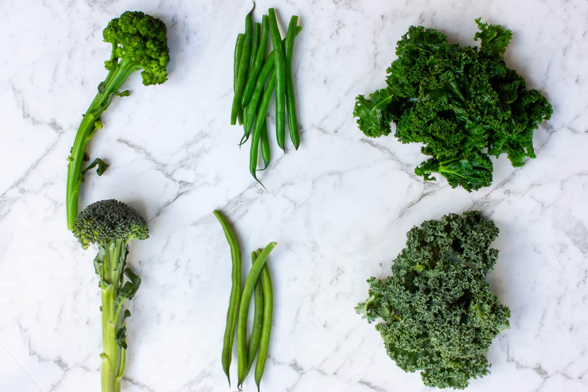 Blanched broccolini, green beans and kale set above unblanched counterparts for comparison.