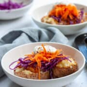 Baked potato split in half and topped with purple cabbage, carrots , baked beans and soured cream.