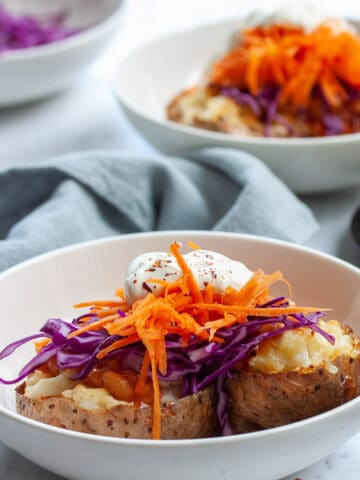 Baked potato split in half and topped with purple cabbage, carrots , baked beans and soured cream.