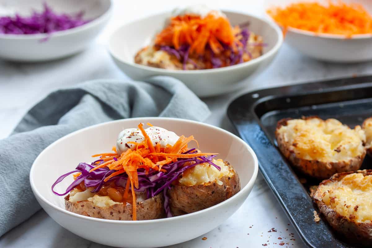 Baked potato split in half and topped with purple cabbage, carrots , baked beans and soured cream.