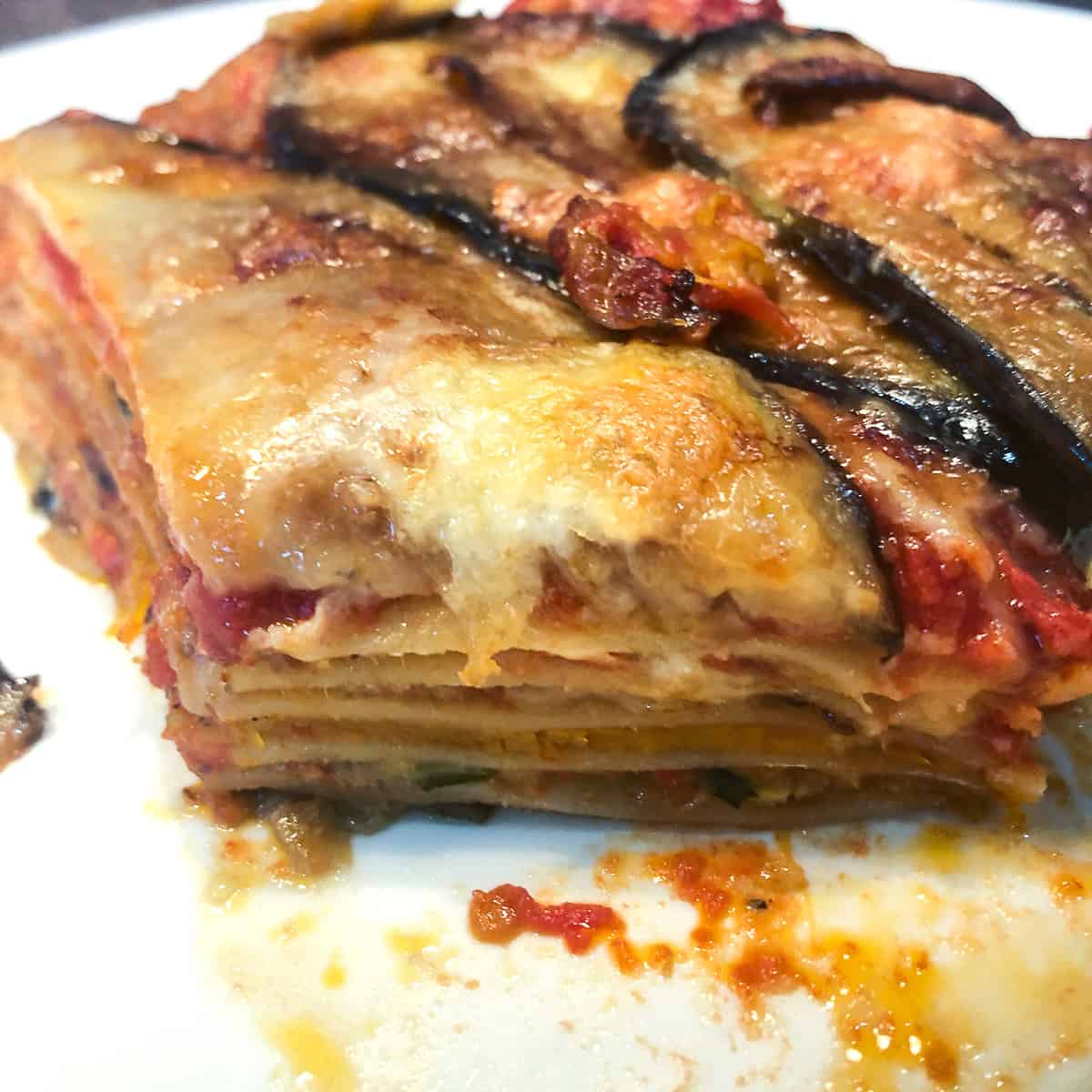 Close-up of a cross section a baked lasagna portion showing five layers of pasta and filling.